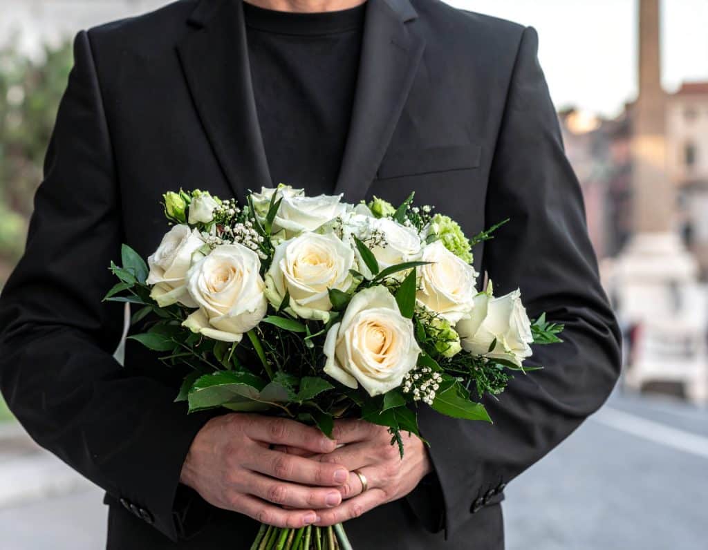 un addetto alle pompe funebri a Roma vestito di nero ed elegante e senza fiori