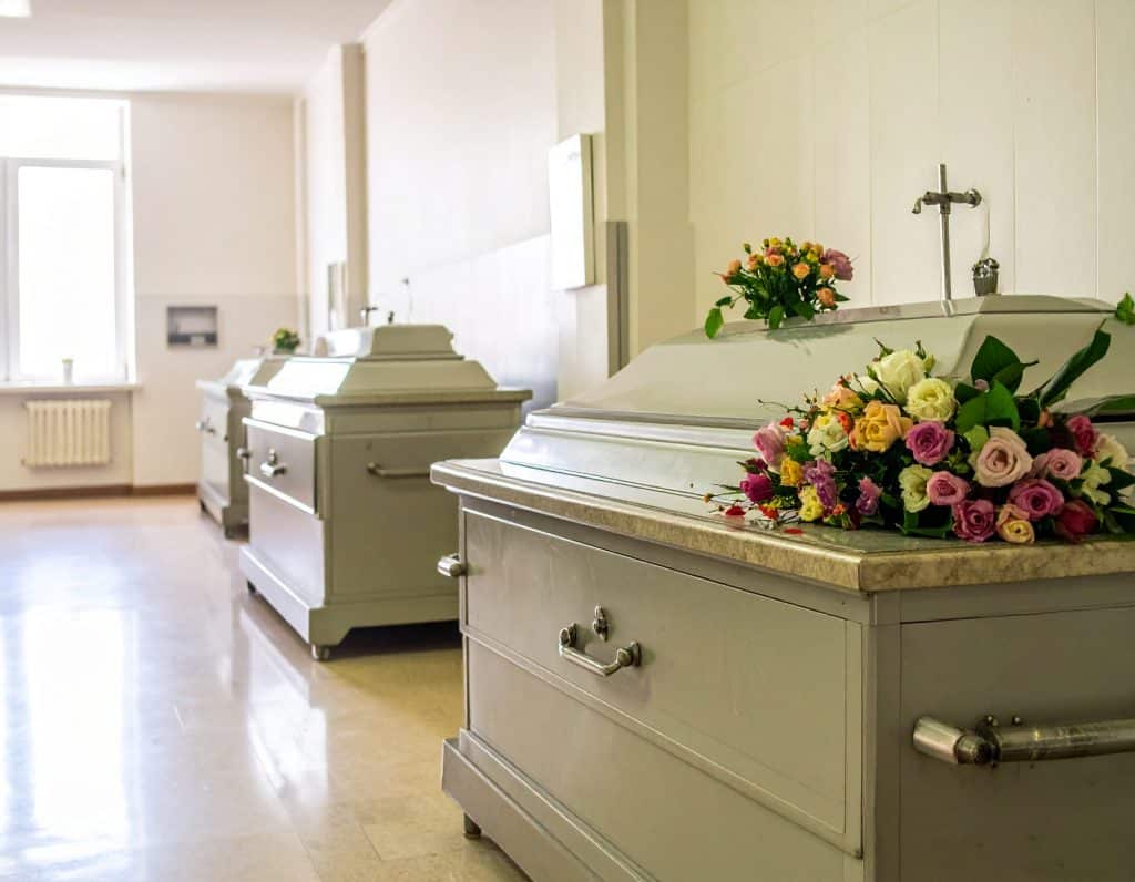 una camera mortuaria a Roma con 3 bare in fila
